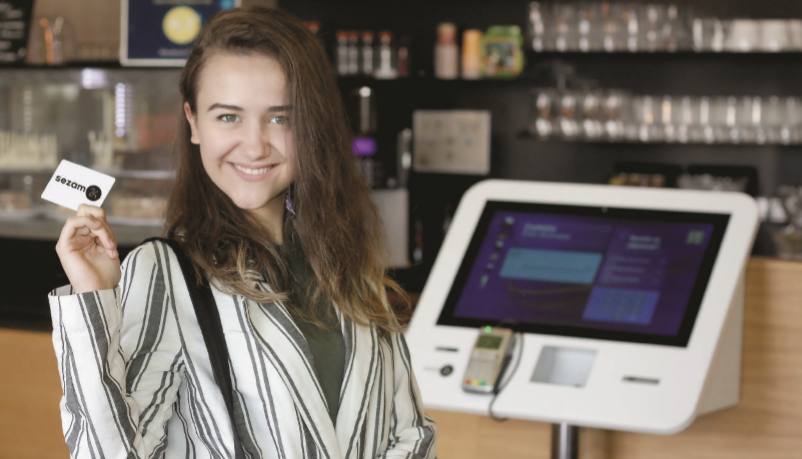 Woman standing next to the Sezam24 automated reception